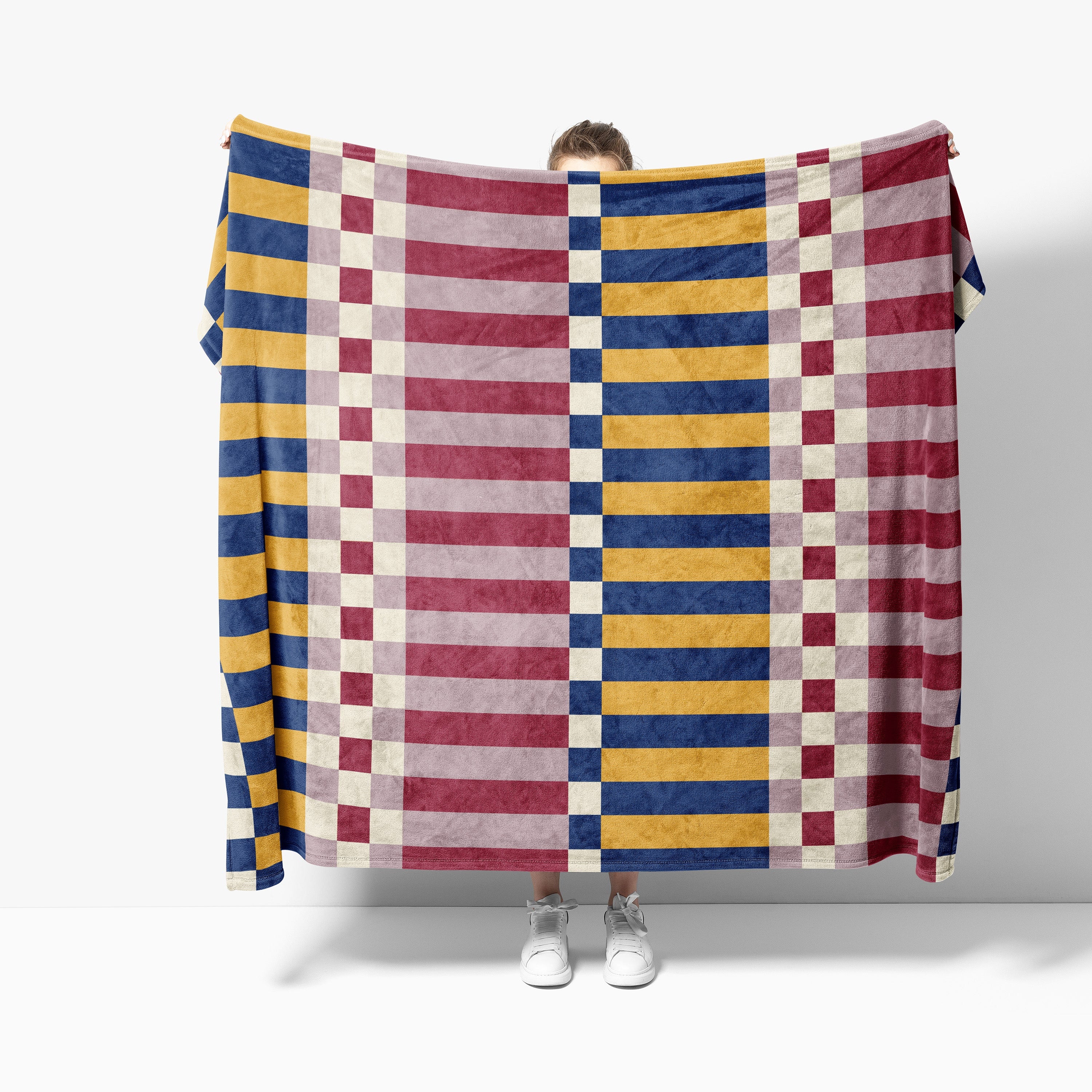 Person holding a colorful striped blanket against a white background